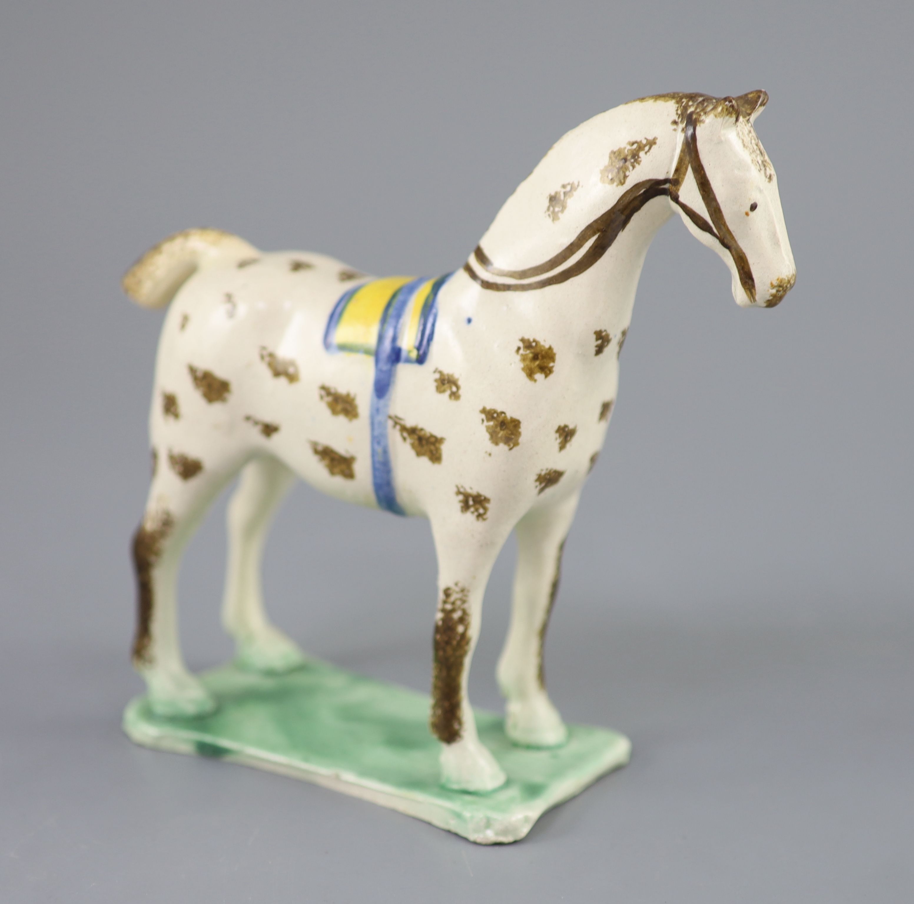 Attributed to St. Anthony Pottery, Newcastle, a pearlware figure of a racehorse with yellow saddle, c.1800-20, 15cm high